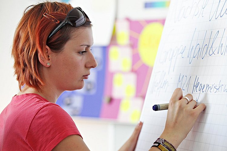Studentin schreibt etwas an die Tafel