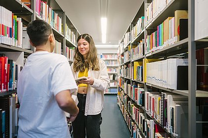 Junge Menschen in der Hochschul-Bibliothek.