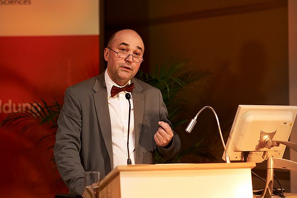 Olaf Neumann steht hinter dem Rednerpult und hält seine Ansprache