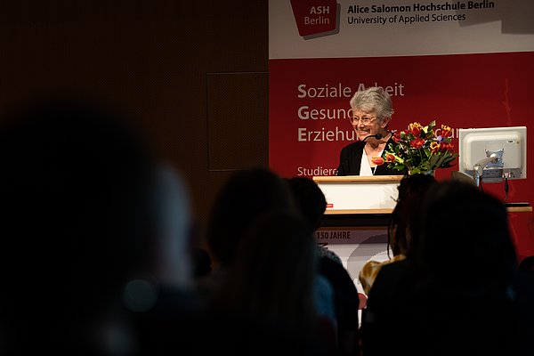 Adriane Feustel auf der Bühne am Redner_innenpult.