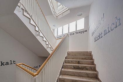 Ein sonnendurchflutetes Treppenhaus im Hochschulgebäude.